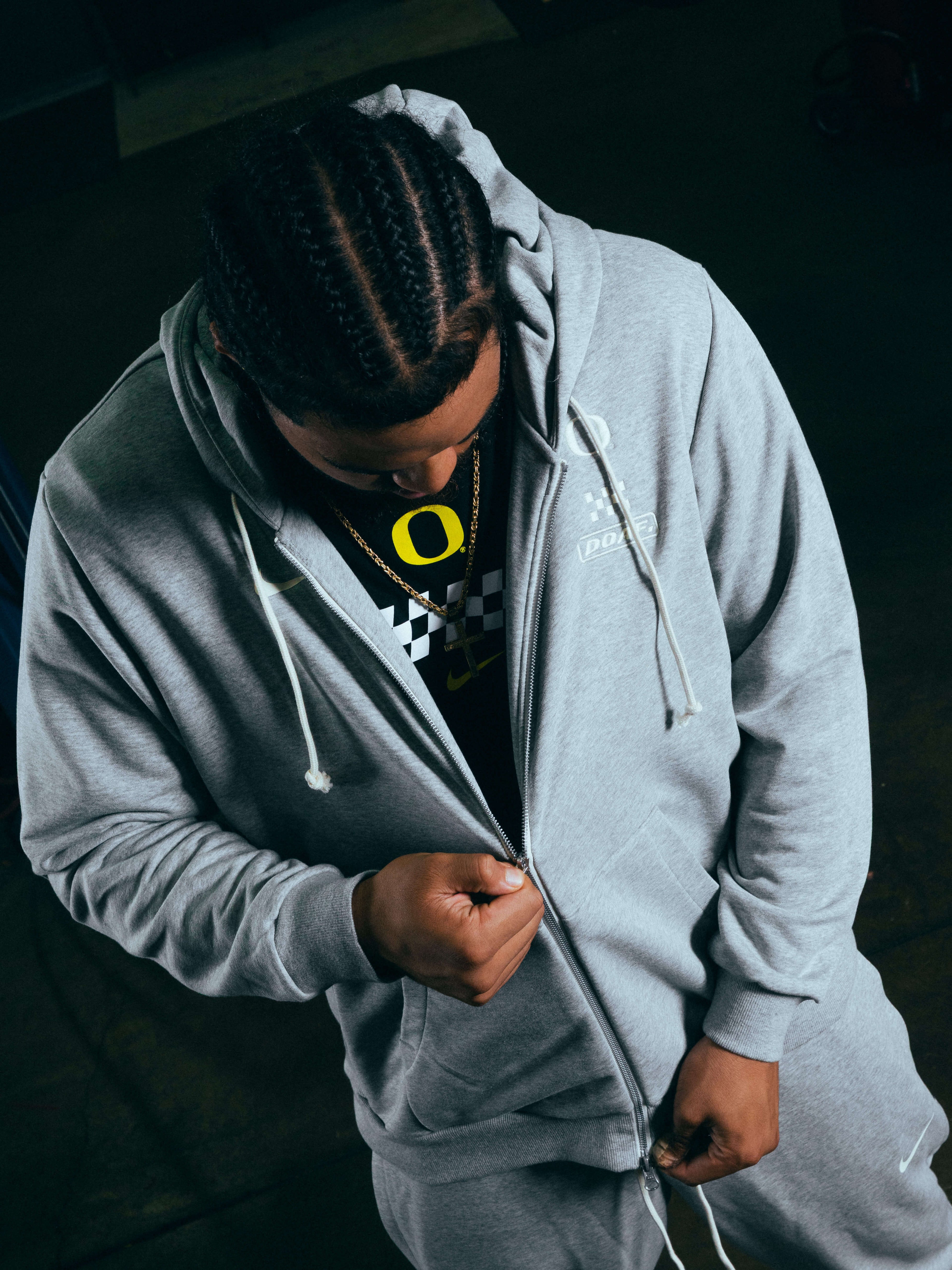 Matayo Uiagalelei wearing a gray DOAF Speedway hoodie with a dark background