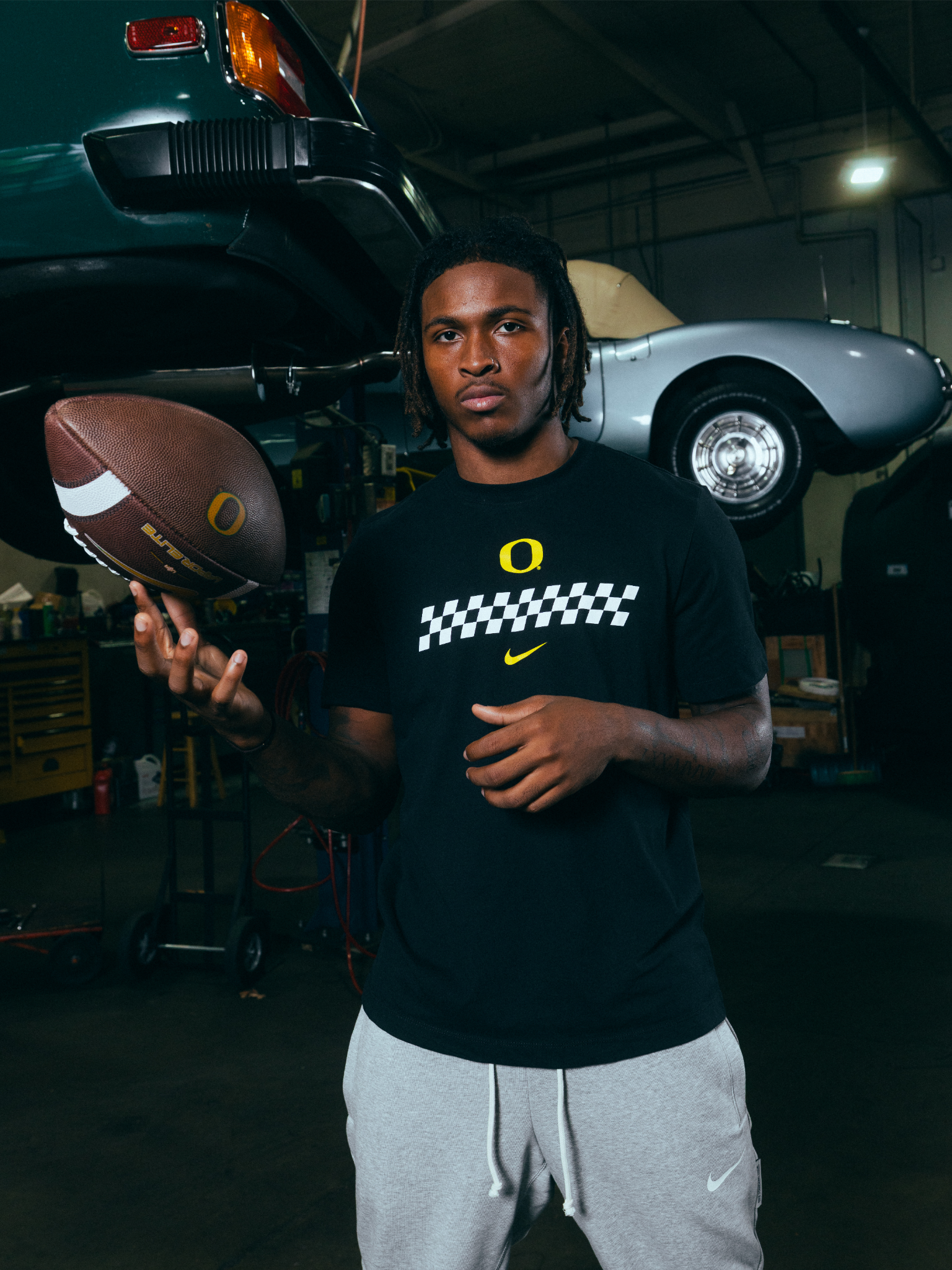 Dakorien Moore holding a football and wearing the DOAF Speedway Tee and Pant