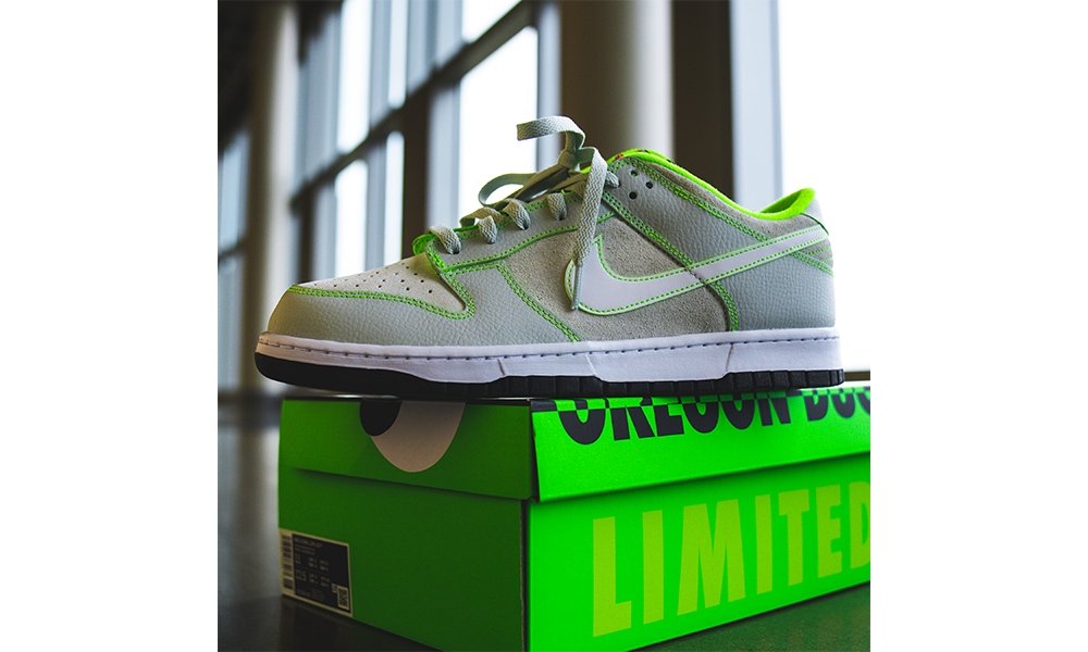 The DOAF Nike Dunk Low “Oregon” Player Edition, offers a fresh take on a classic shoe, with subtle interplays of texture and color highlighted by distinctive signature touches.
The shoe features a subtle tone-on-tone combination of off-white split suede quarter panels and toe boxes, and overlays of light grey tumbled leather accented by electric green stitching throughout, which also outline the white leather Swoosh branding.