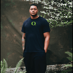 Ziyare Addison wearing a black DOAF t-shirt with a green logo against a natural background