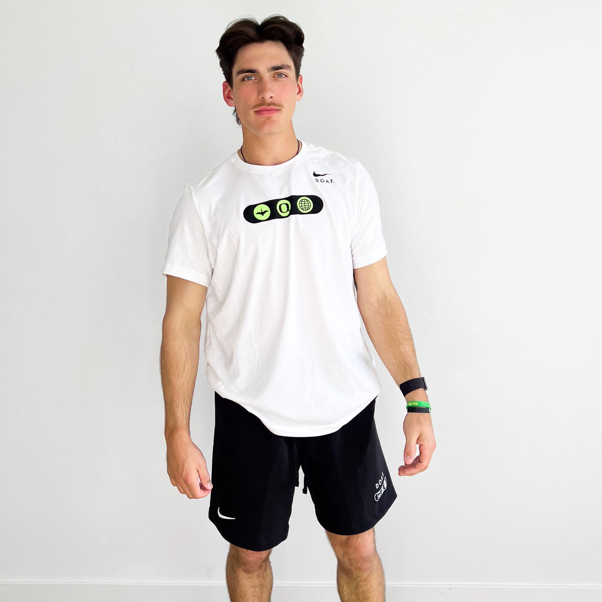 Anson Aroz wearing a white DOAF World wide webbed t-shirt and world wide webbed black shorts with visible branding against a plain background.
