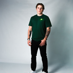 Atticus Sappington wearing a green DOAF t-shirt with a logo on a gray background