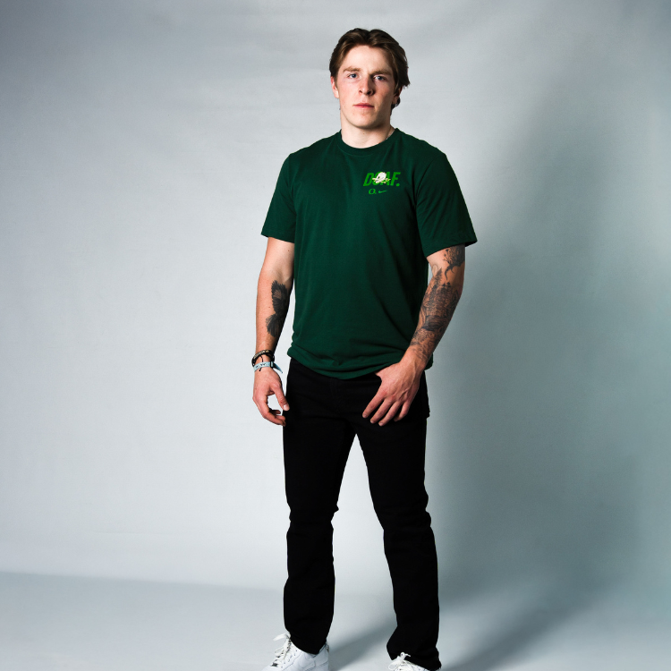 Atticus Sappington wearing a green DOAF t-shirt with a logo on a gray background