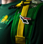 Green bag with yellow strap featuring a enamel pin with a DOAF logo on a dark background