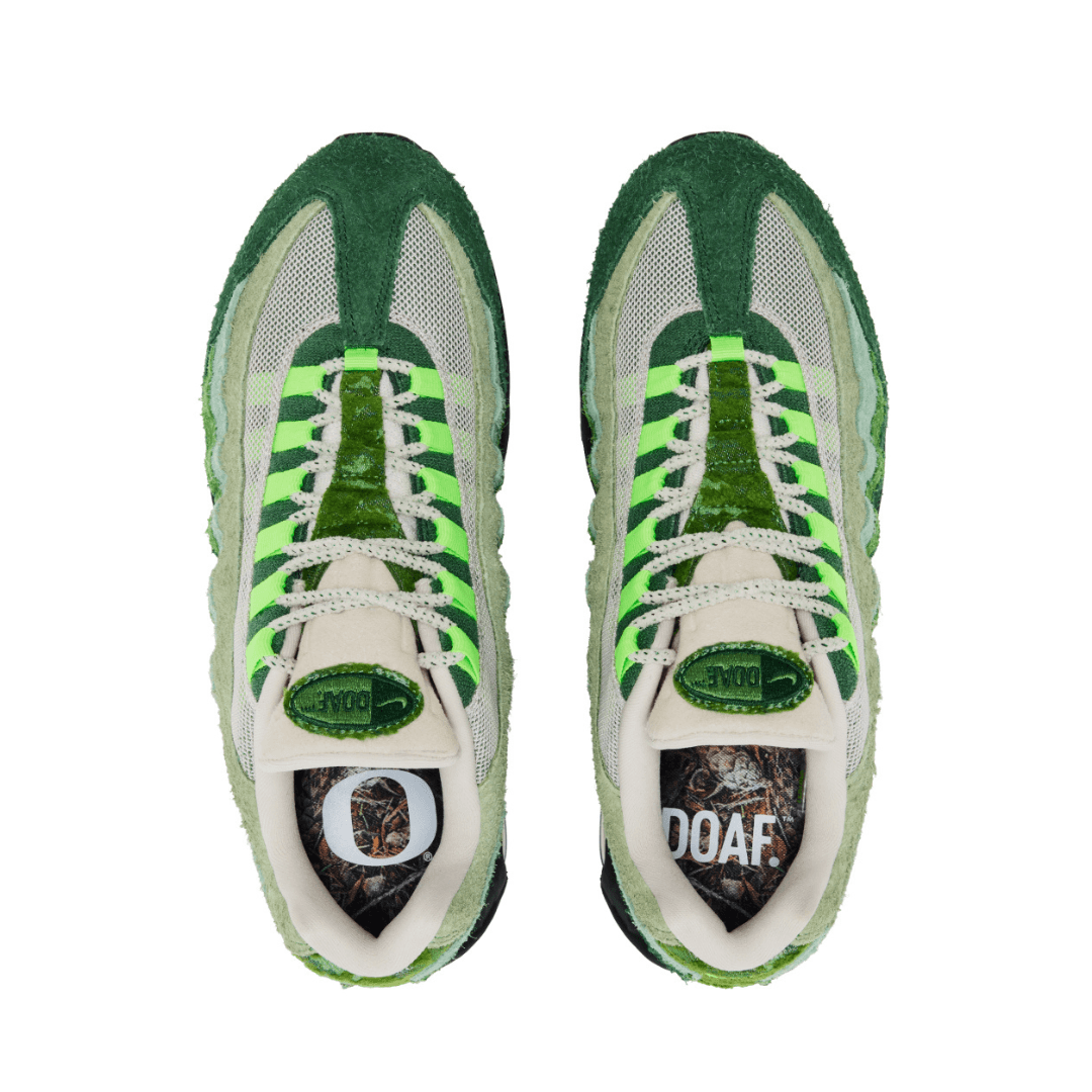 Green and white Air Max 95 sneakers with a DOAF logo on the sock liner on a white background
