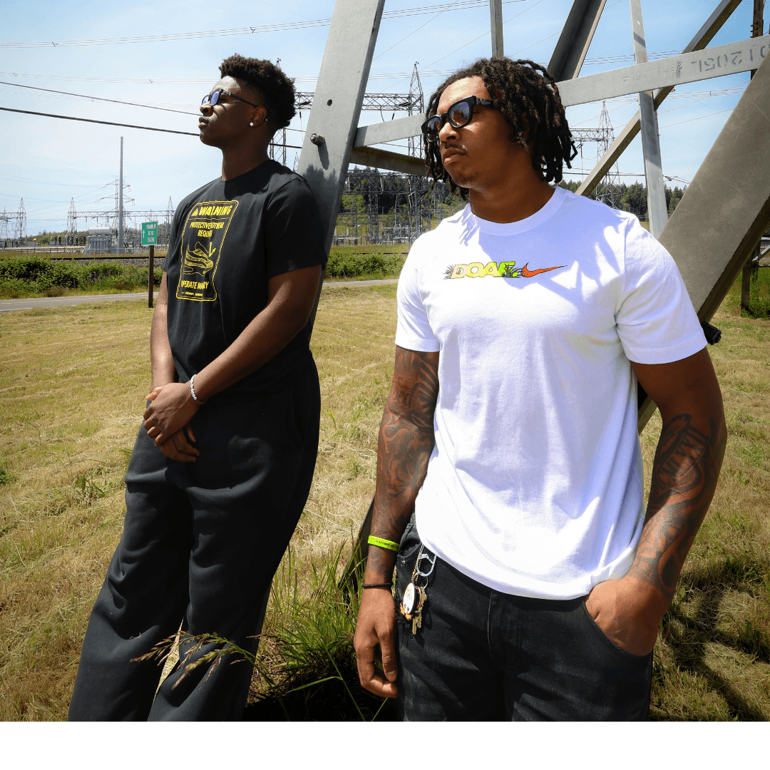 Two men standing outdoors with power lines and a clear sky in the background