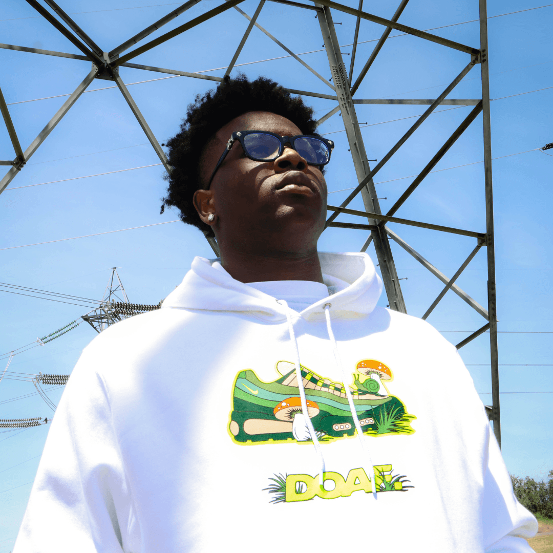 Athlete wearing a white hoodie with a sneaker graphic in front of power lines.