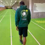 Safin Wills wearing a green World Wide Webbed hoodie an indoor running track